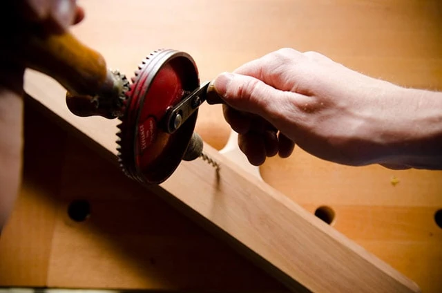 Boring A Hole In A Wood Plane With A Manual Hand Drill Or Egg Beater Drill