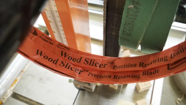 1/2 Inch Wood Slicer Precision Resawing Blade In Orange Paper Packaging With A Bandsaw In The Background