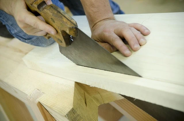 Woodworker Ripping A Board With An Antique Disston Hand Saw