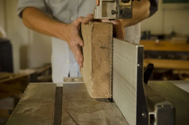 Woodworker Resawing A Thick Walnut Board On A Bandsaw With A Resaw Fence