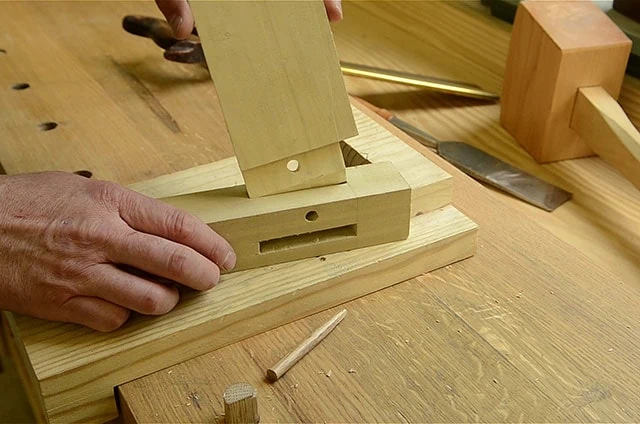 Woodworker Inserting A Tenon Into A Mortise On A Table Leg Mortise And Tenon Joint