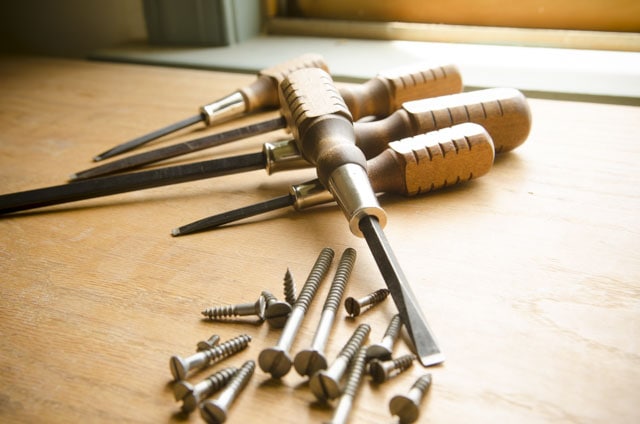 Grace Brand Screwdrivers Sitting On A Woodworking Workbench With Historical Style Slotted Screws