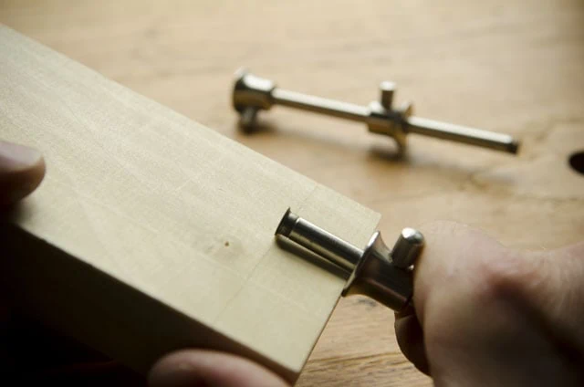 Veritas Small Round Marking Gauge Cutting A Layout Line Held Over A Roubo Woodworking Workbench