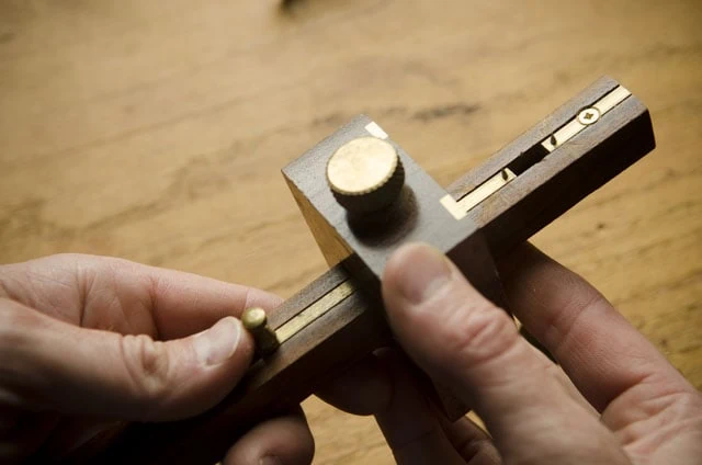 Crown Mortise Gauge Held Over A Roubo Woodworking Workbench